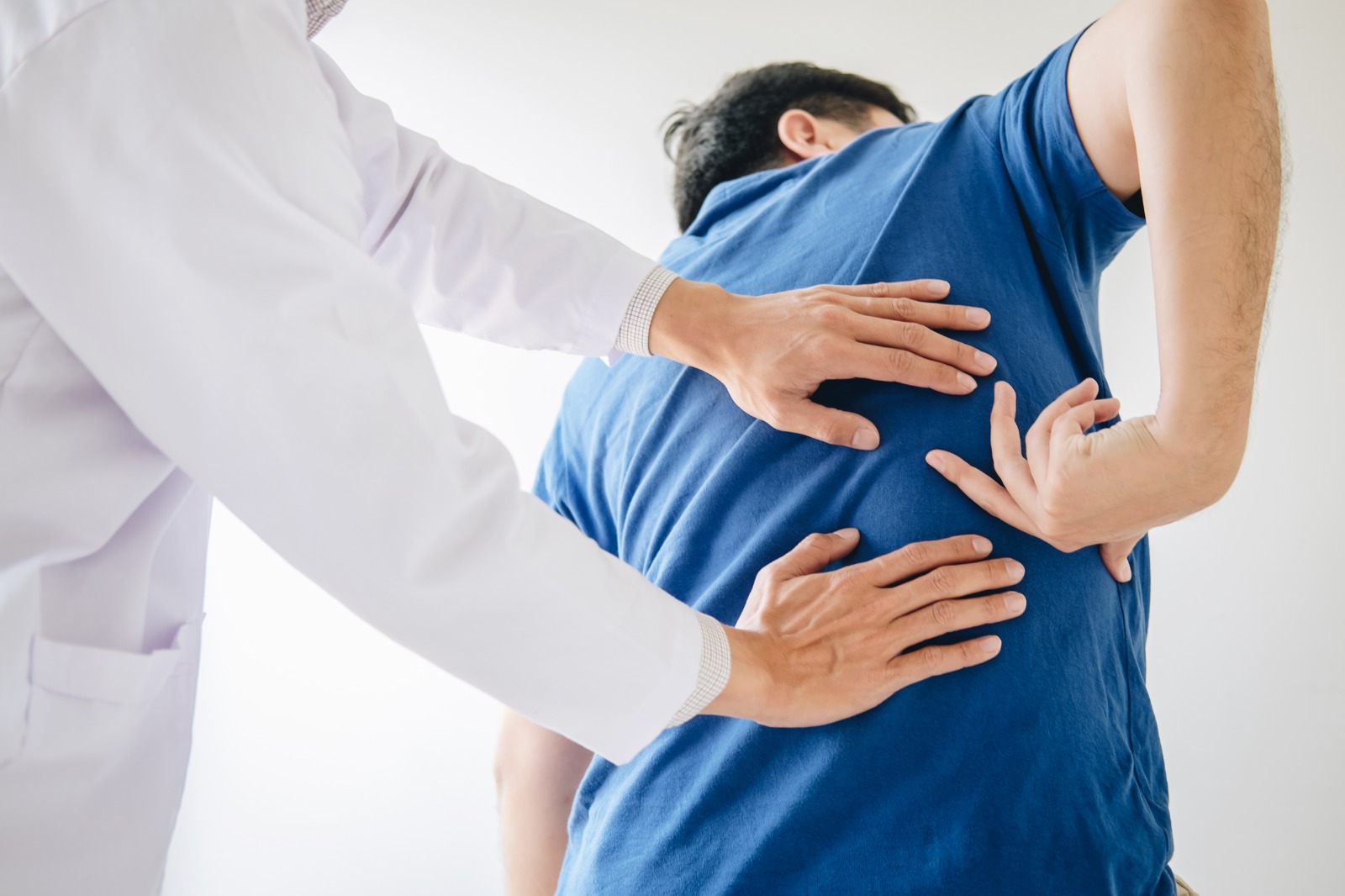 médico revisando espalda de paciente
